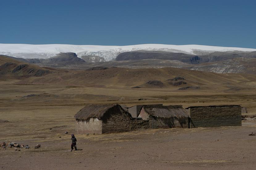 Farm in Quelccaya, Peru. 2003. The grassy field transitions into a snowy landscape in the distance 