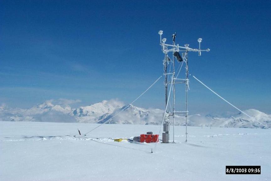 Research site in Quelccaya, Peru. 2003. A large antenna is positioned in the middle of a vast snowy landscape  