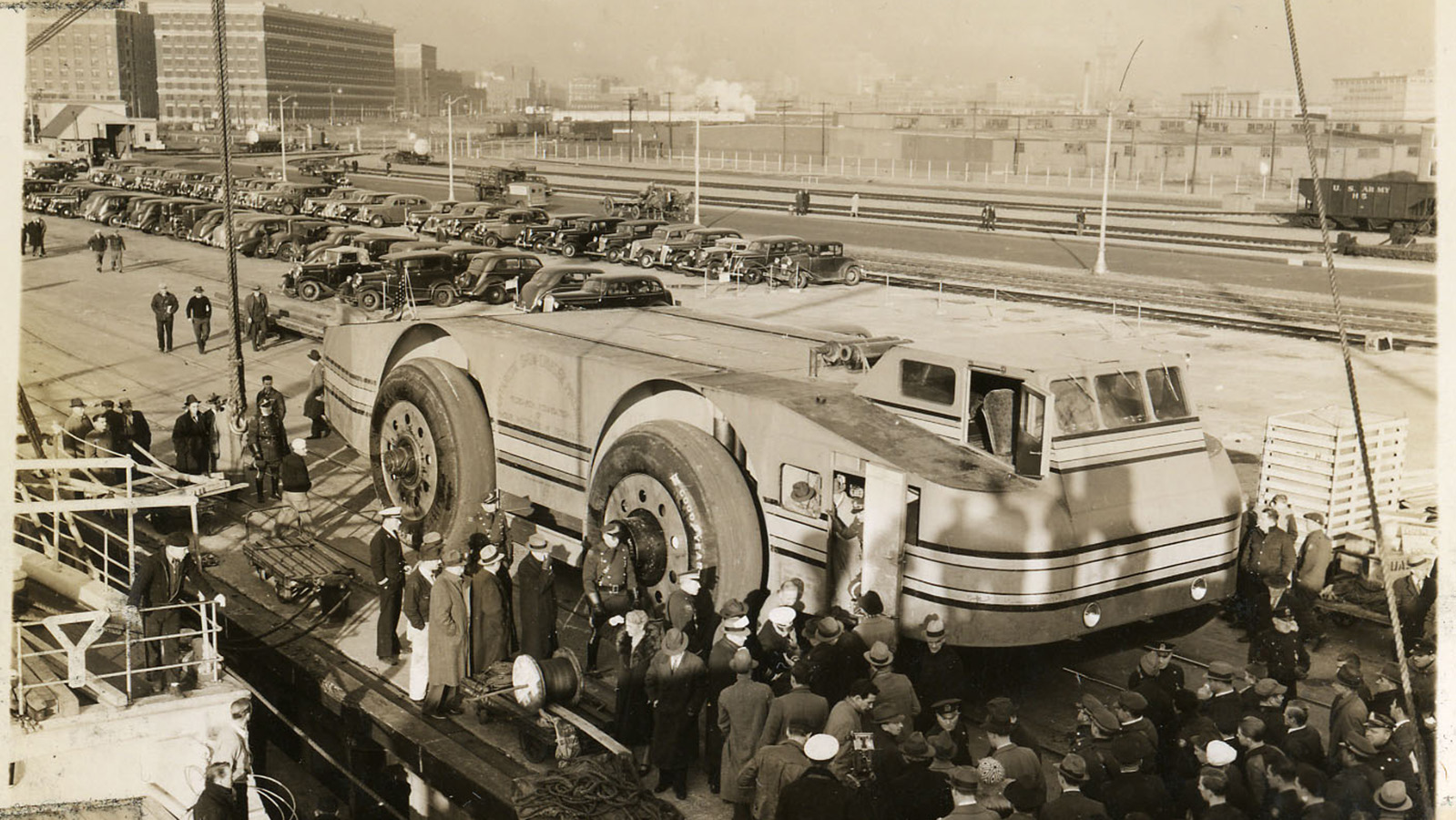 black and white photo of a snow cruiser in a city surrounded by a crowd of people