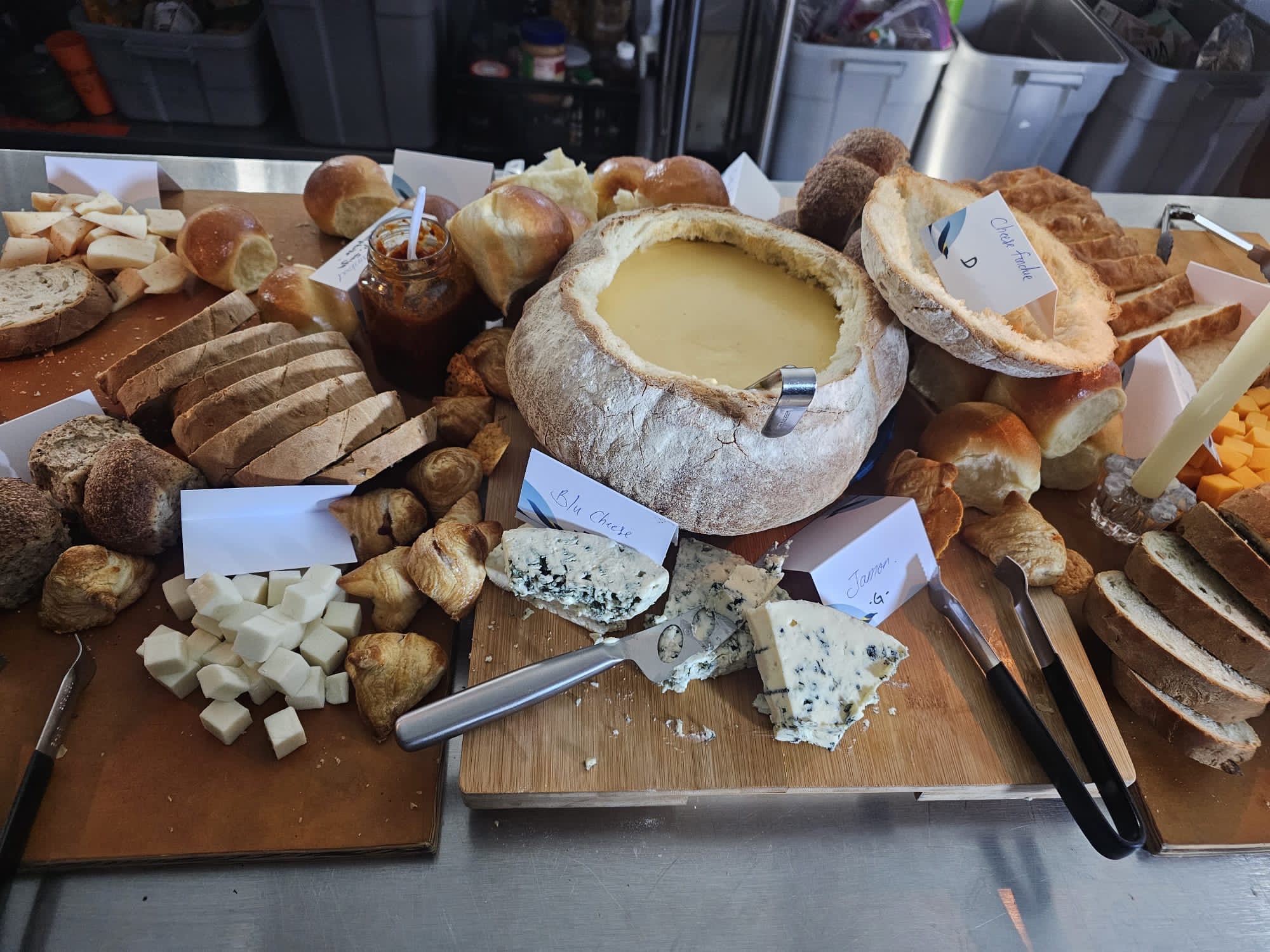 Table filled with different, breads, cheeses and spreads.
