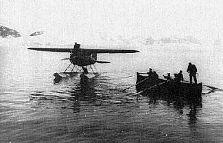A black and white image of a plane and boat on the water.