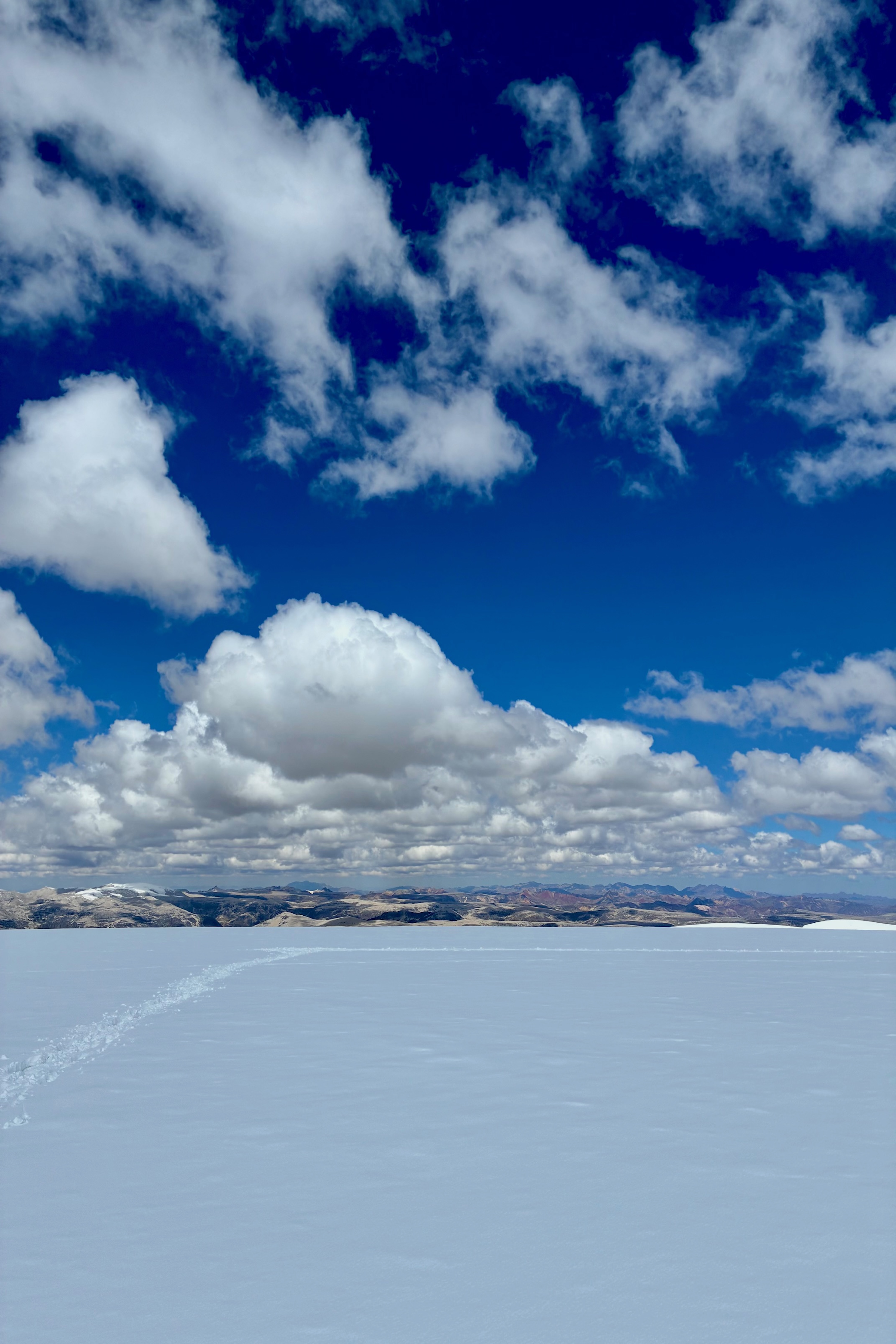 An ice-covered landscape with mountains on the horizion