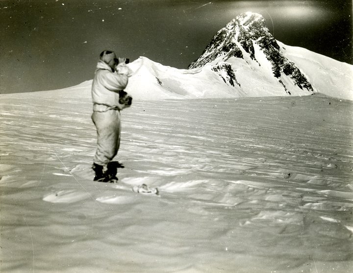 Person standing in snow with mountain in background