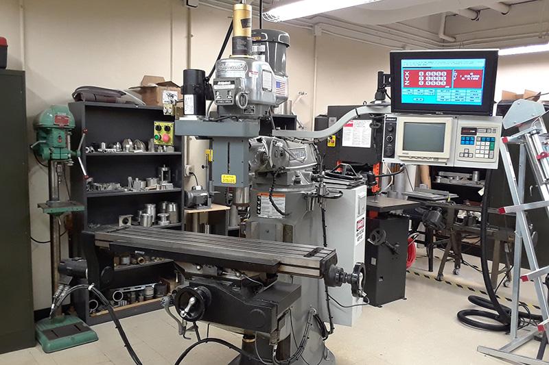 A computer numerical control milling machine (CNC mill) surrounded by other fabrication tools