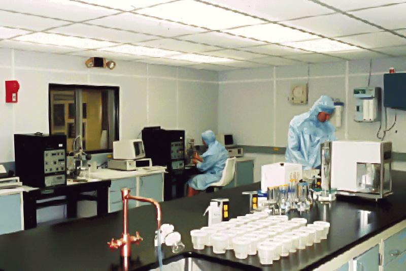 Ice core lab facility with two scientists in protective clothing and various scientific instruments