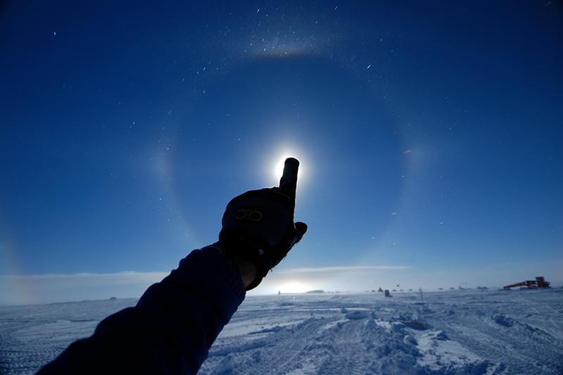 Person surrounded by ice and pointing at the sun