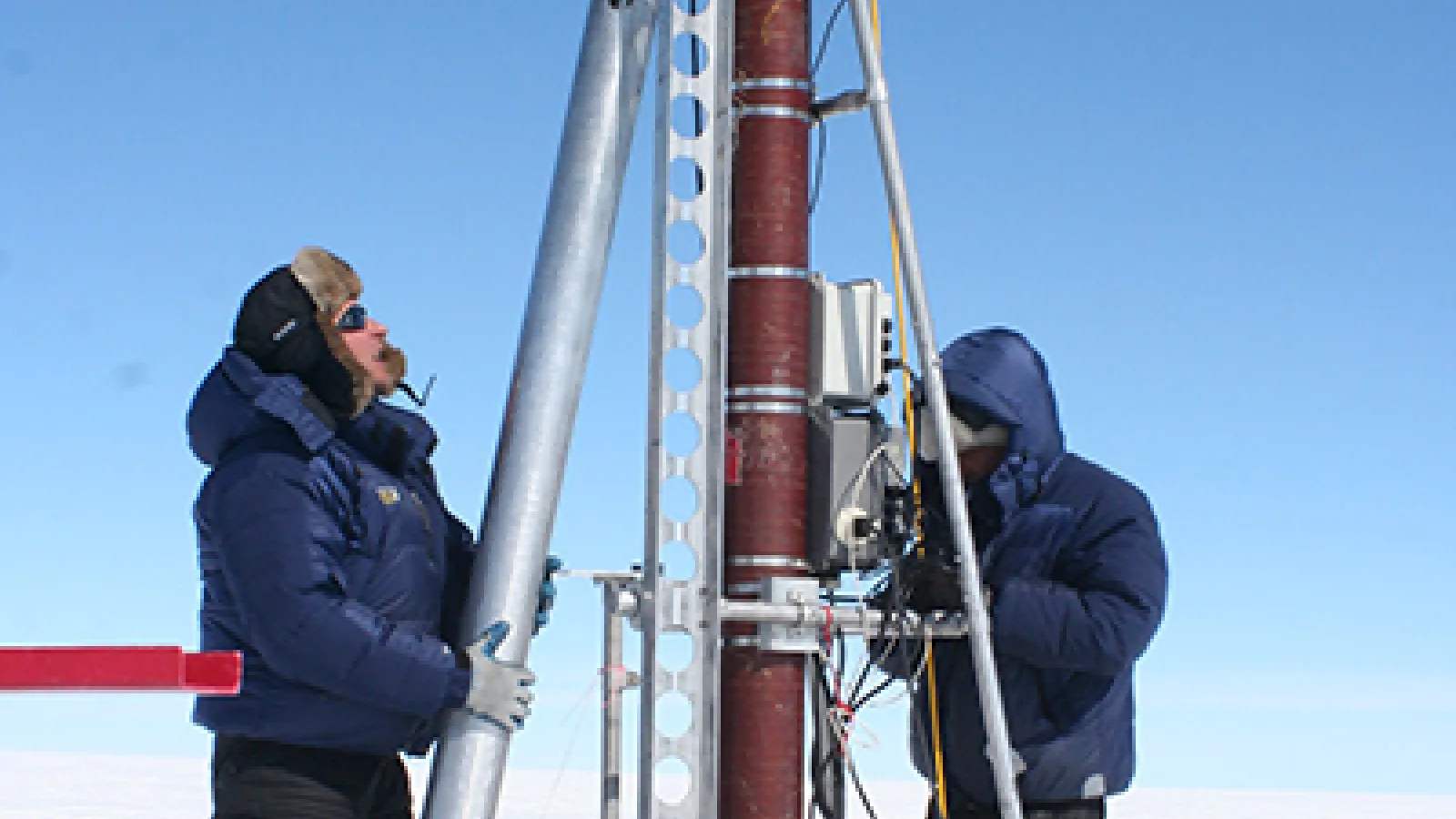 2 researchers use Ice core drilling equipment.