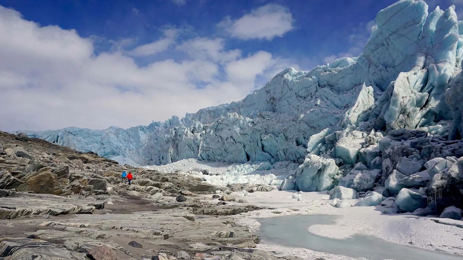 Glacier landscape against a blue sky with white fluffy clouds 