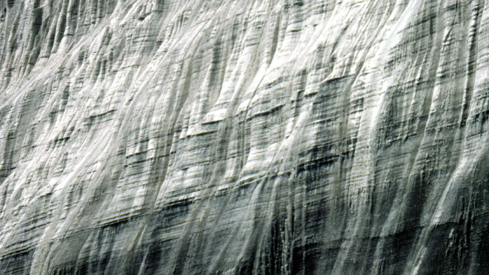 A massive wall of ice under blue skies.