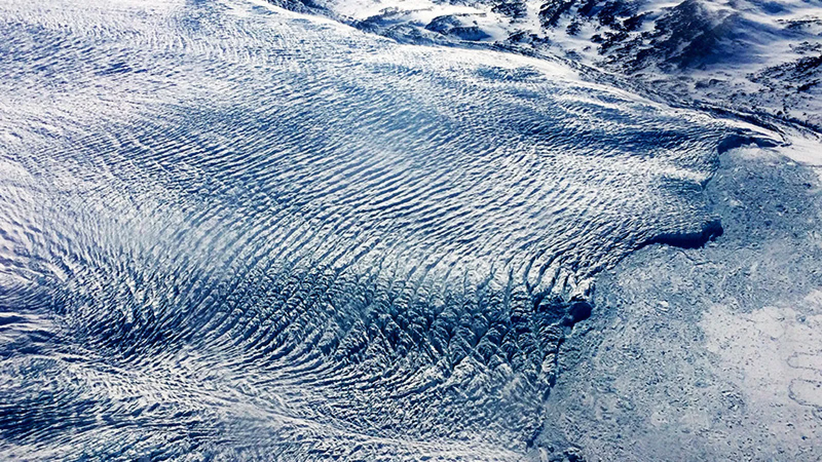 A glacier with a ripple like effect across the top of it