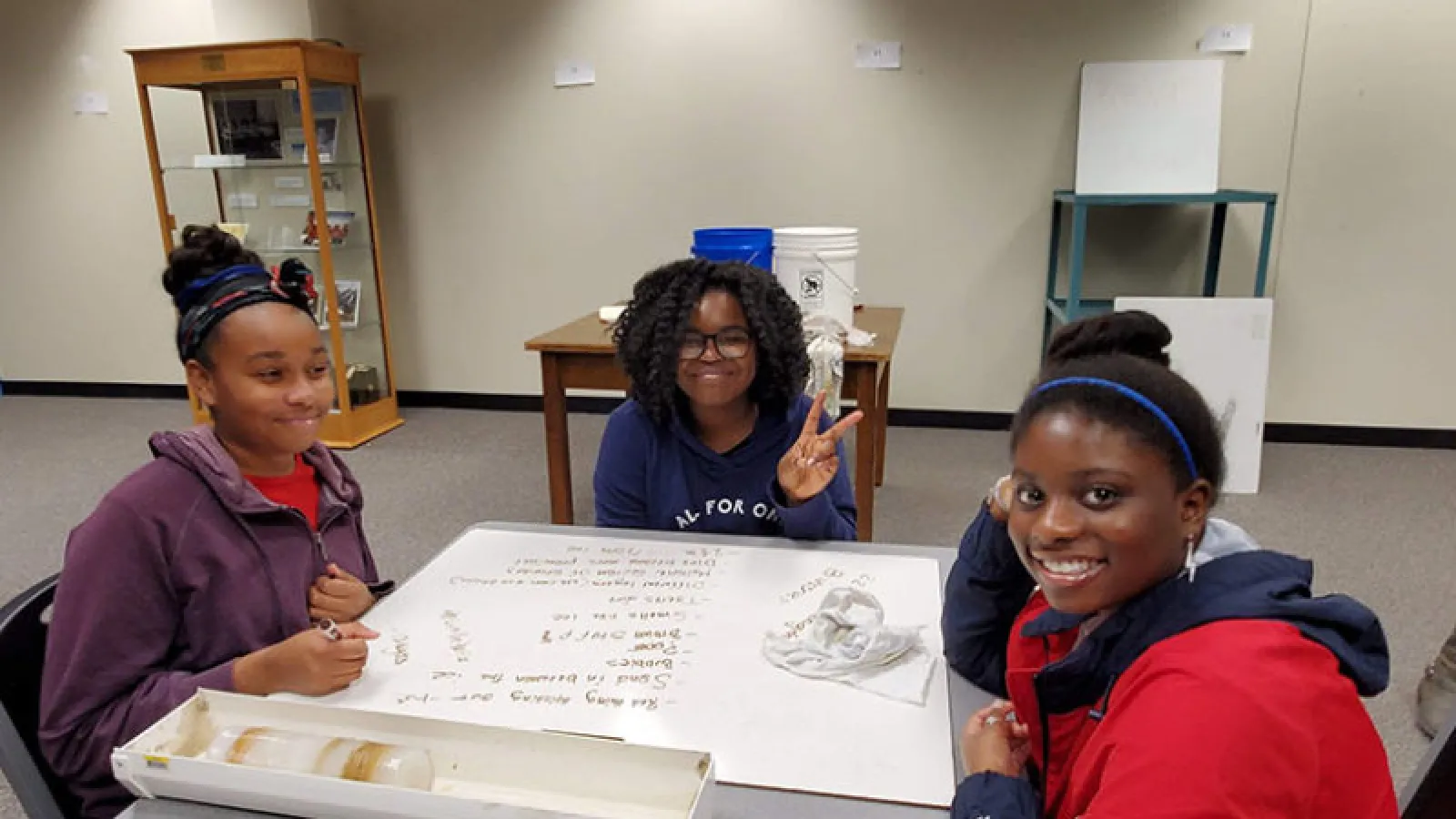 three Students sit around a table and make their own ice cores at the Byrd Center