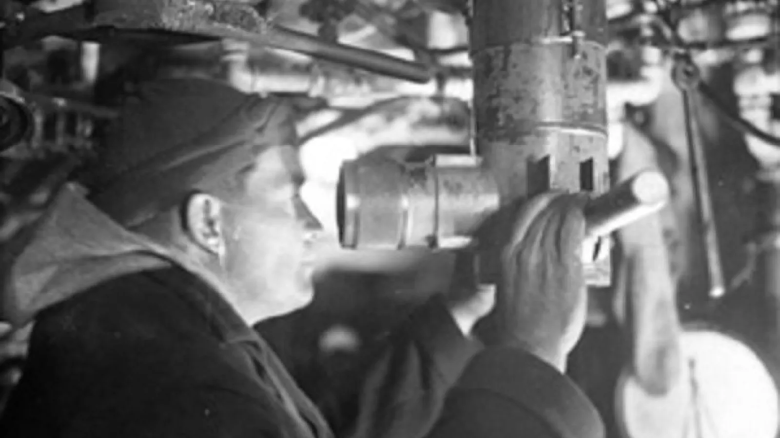 Man looking through submarine telescope
