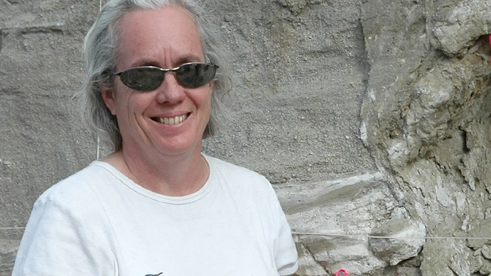 Terry Wilson smiling for a photo in front of a rock
