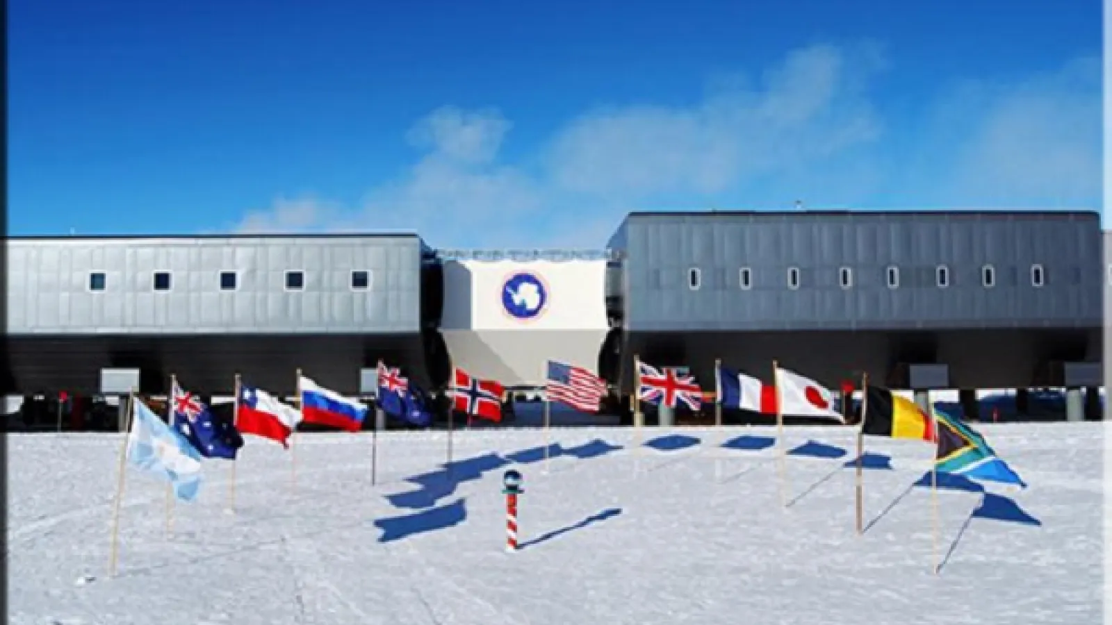 South Pole with flags and station in background
