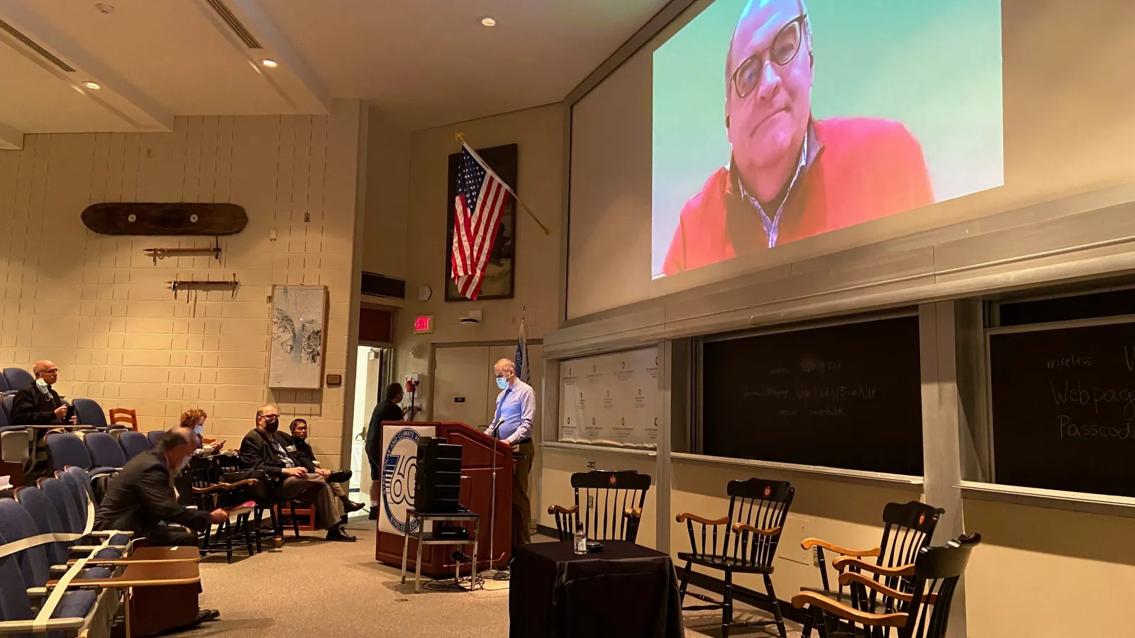a man stands at a podium giving a presentation to an auditorium 