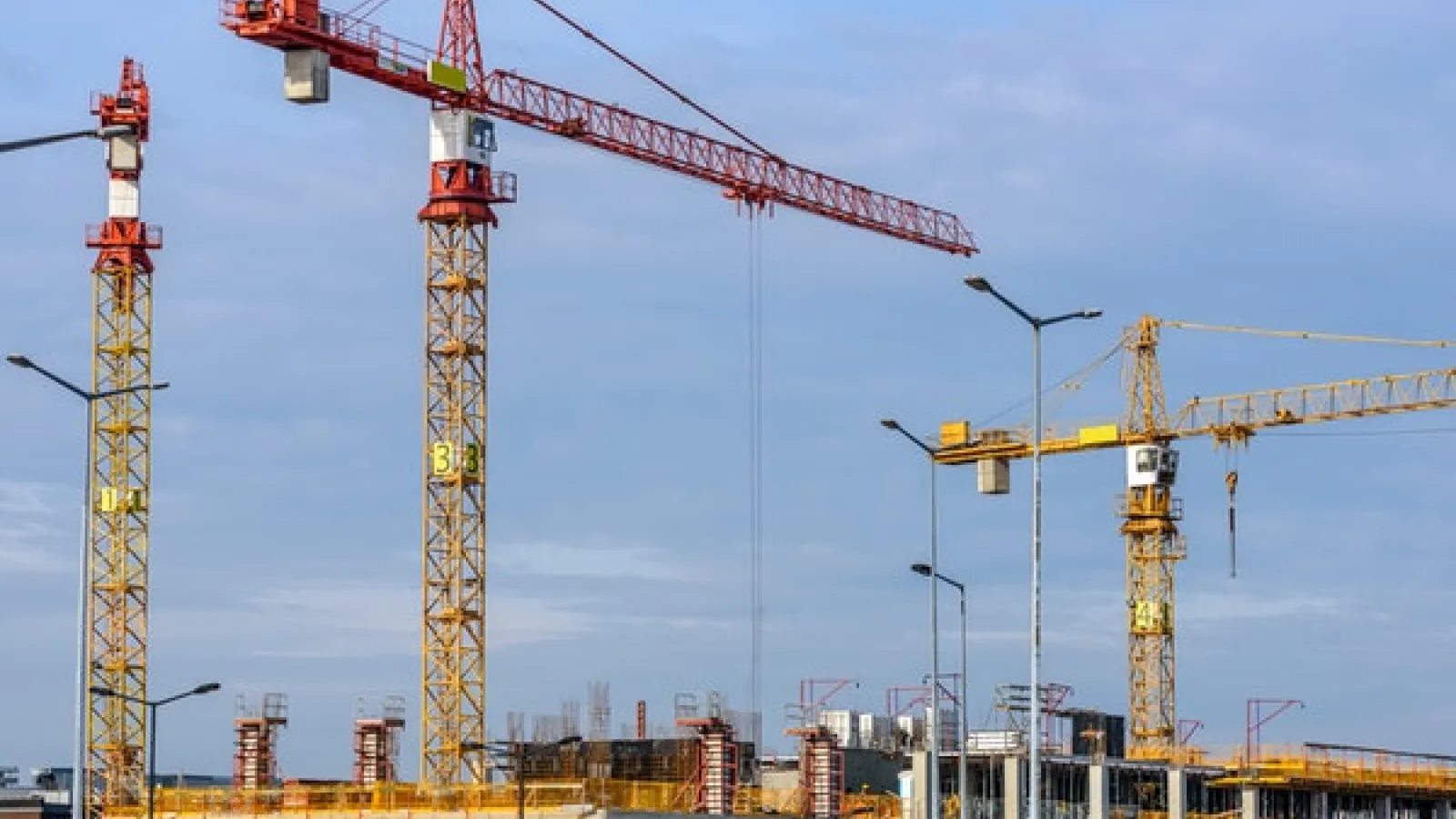 Top floor of building under construction and cranes