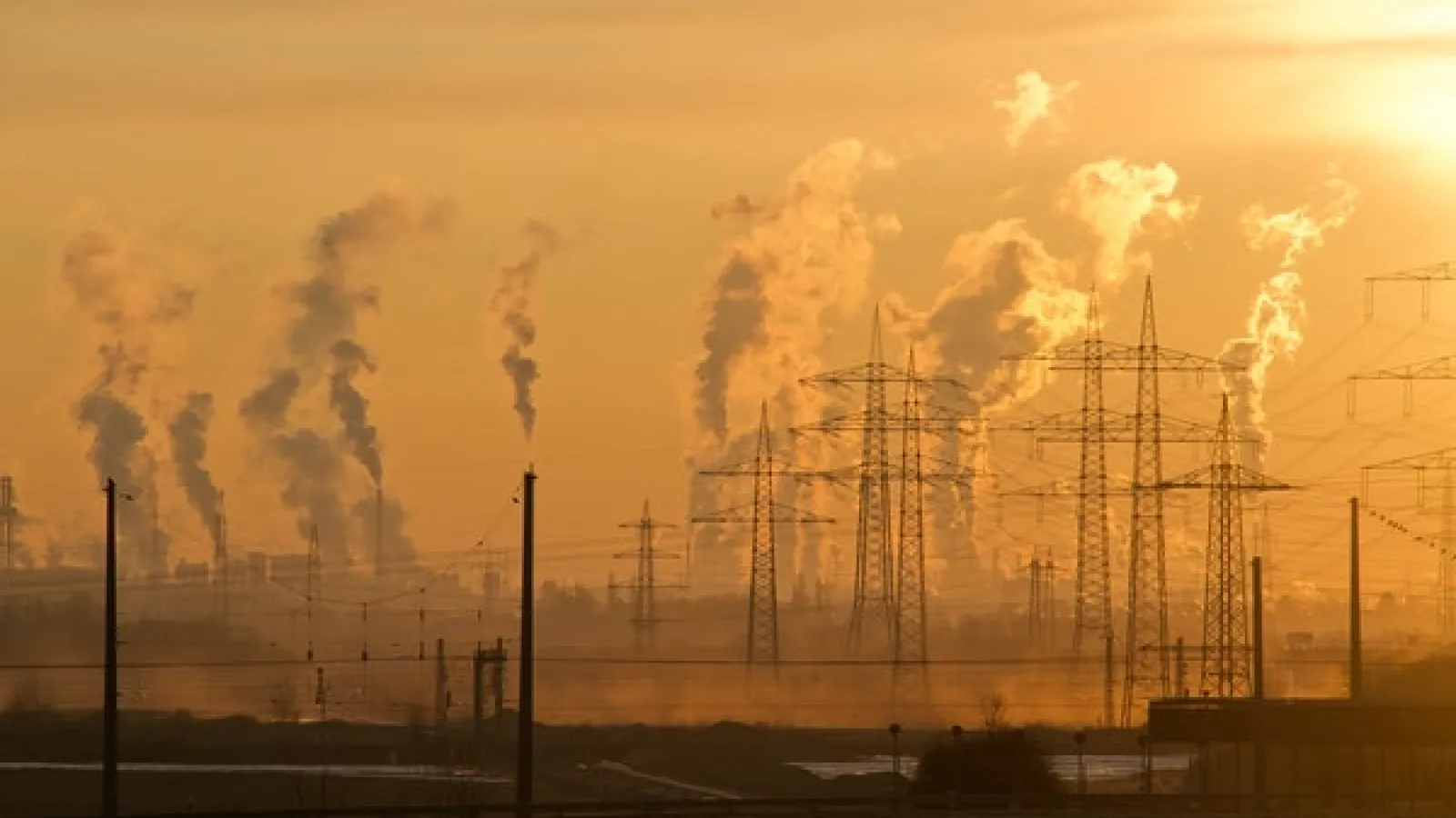 Sunrise scene of electric towers and smoke stacks