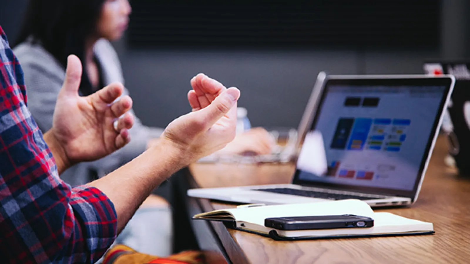 man talking in a meeting with while using computer
