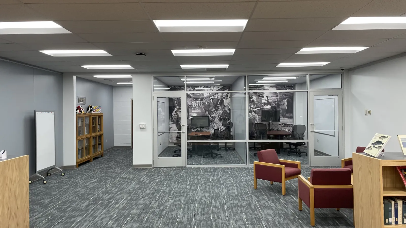 The back half of the Goldthwait Polar Library, with chairs to the left, glass rooms in the back, and a corridor to the right side of the back wall