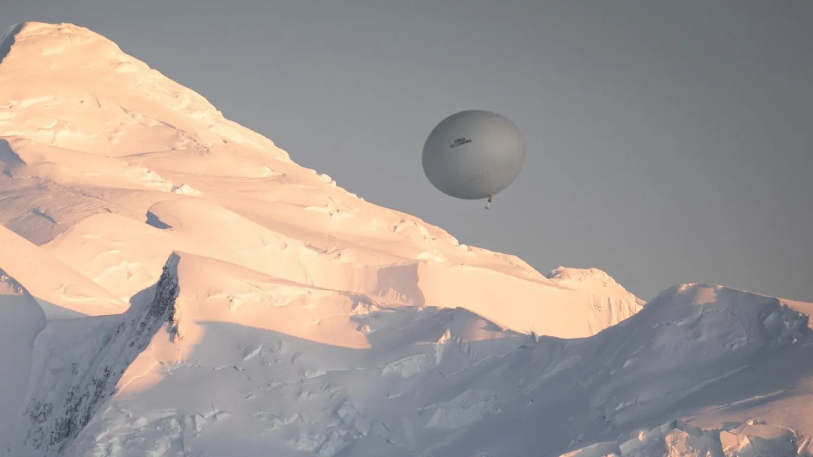 Balloon flying in the sky backdrop of snow covered mountain