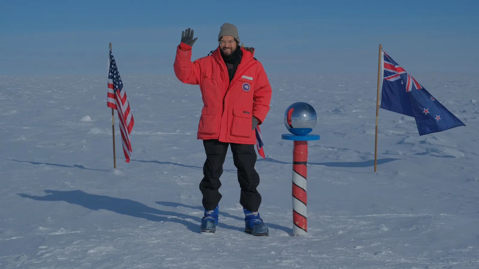 Karsten standing and waving at the South Pole