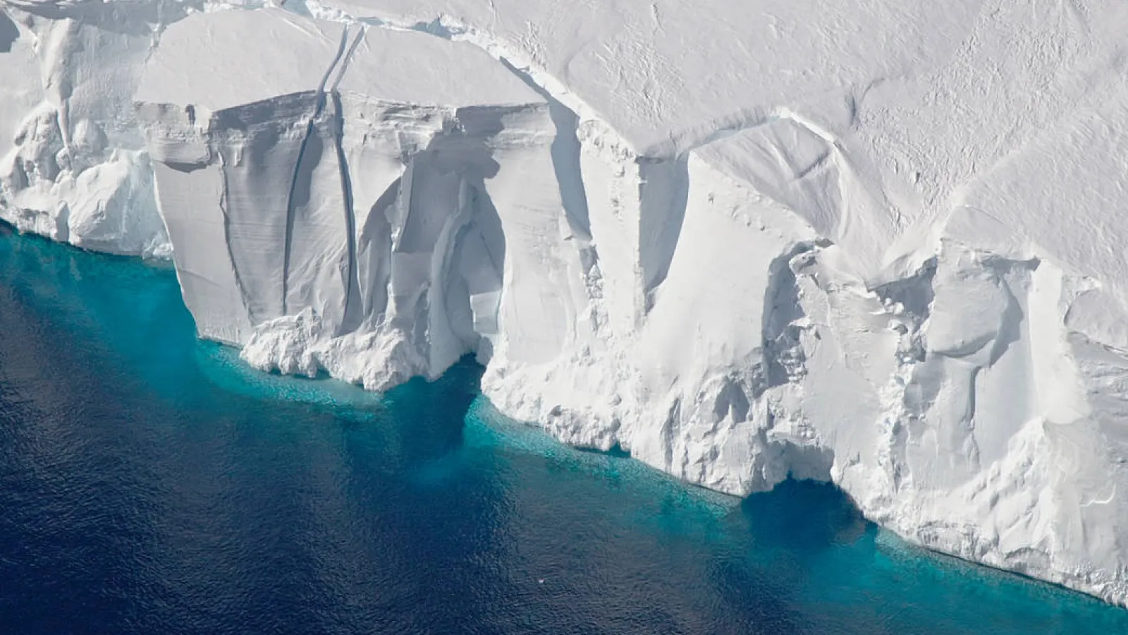 Getz Ice Shelf - white mountain of ice in clear blue water.