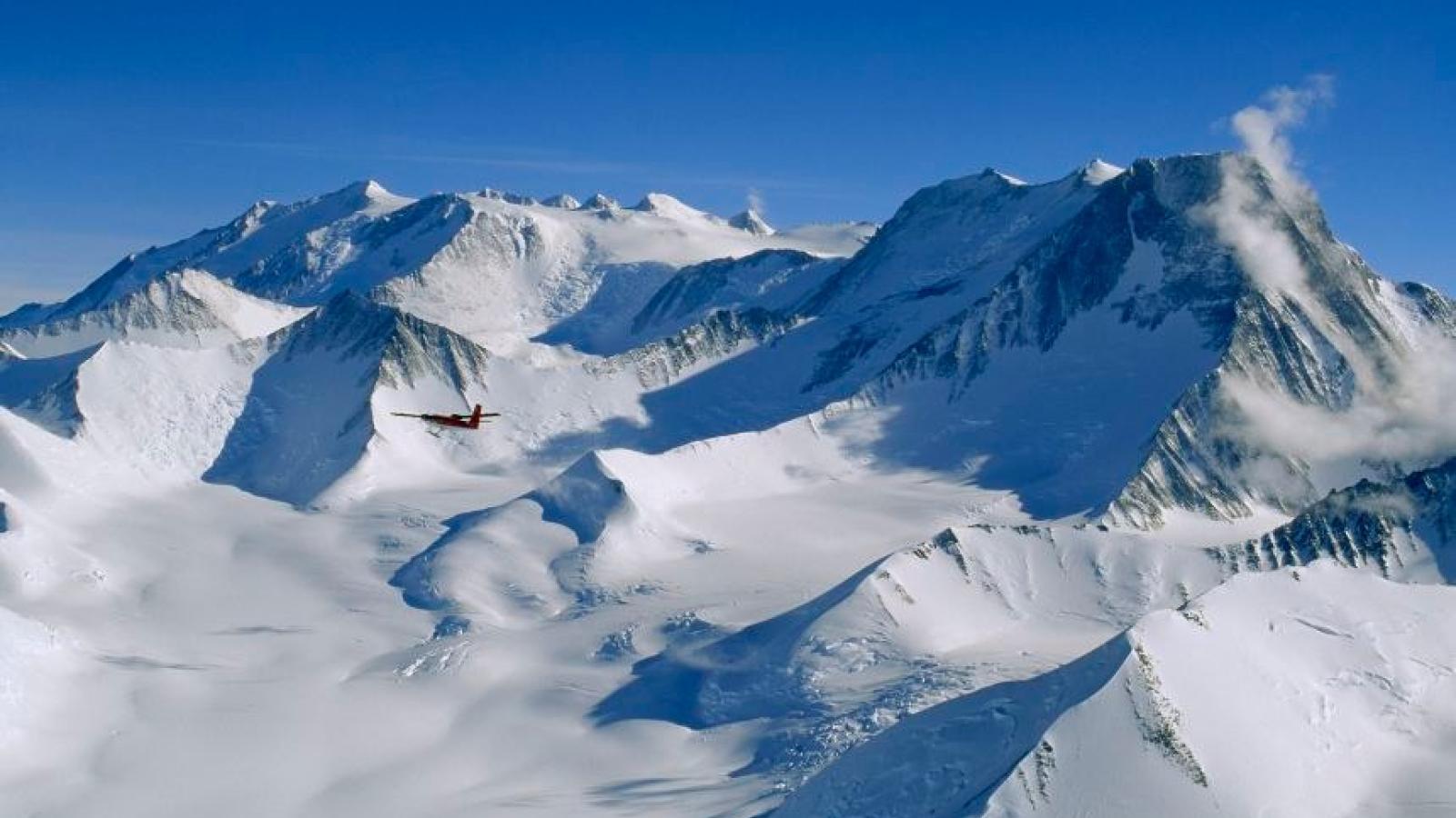 A snow covered mountain range under clear blue skies.