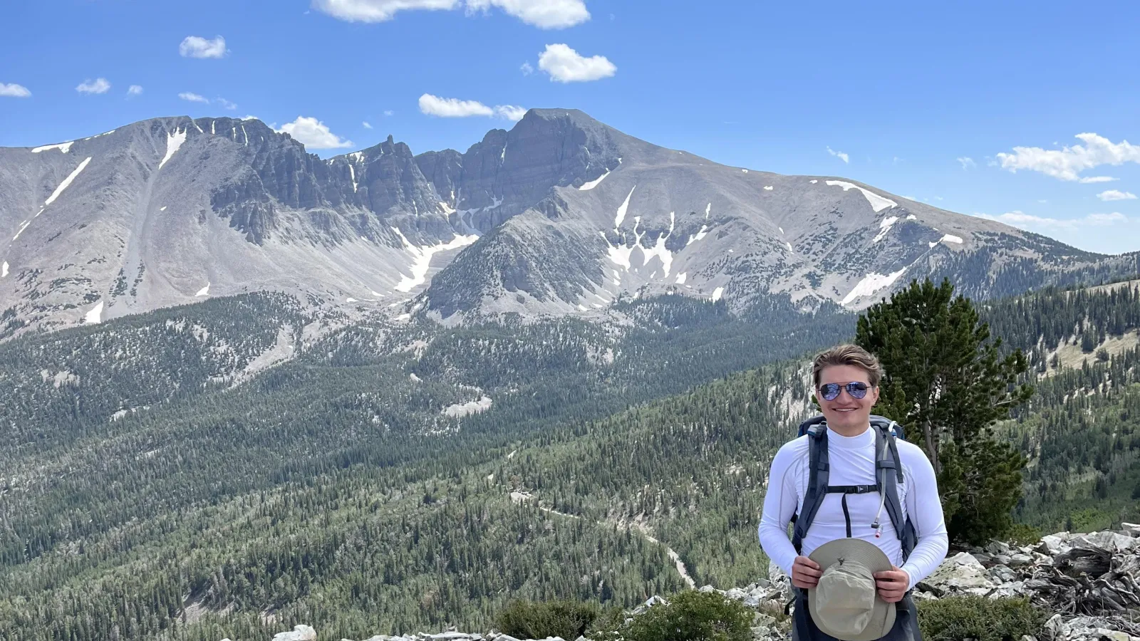 Harrison Frenken in a rocky, mountainous region under blue skies with white clouds.
