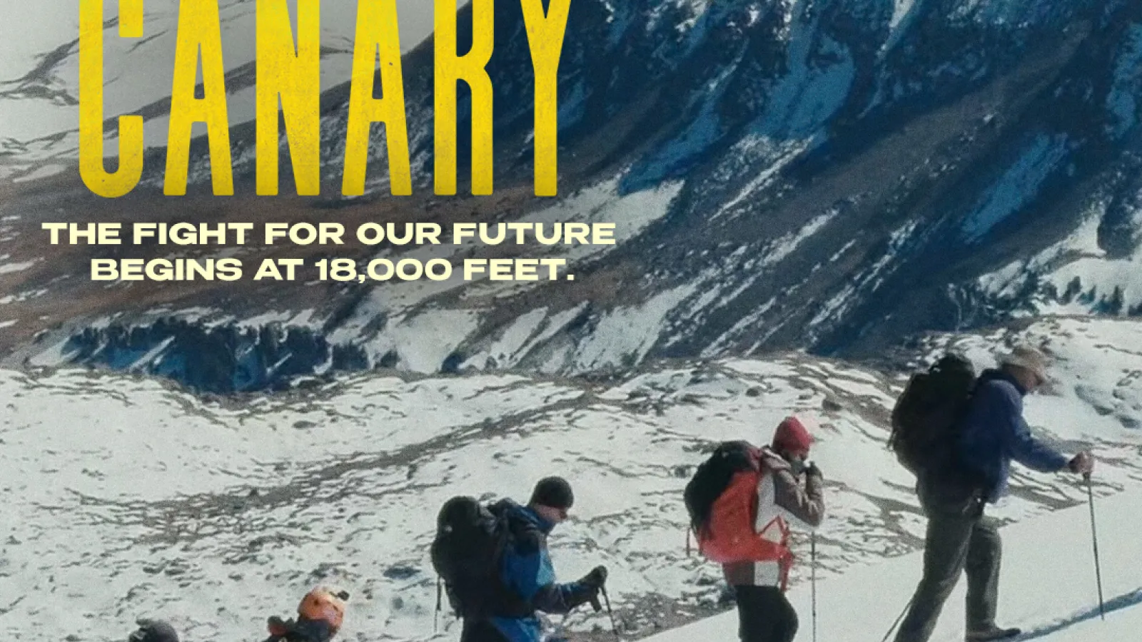 A group of 5 people walking in a row climbing a snowy hill on the mountain.
