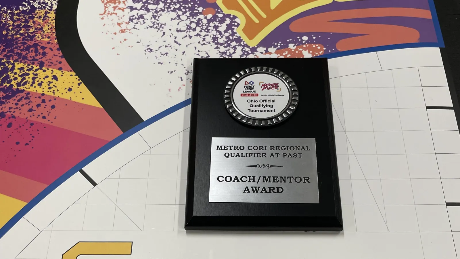 a plaque on a colorful table that says Master Piece on it,