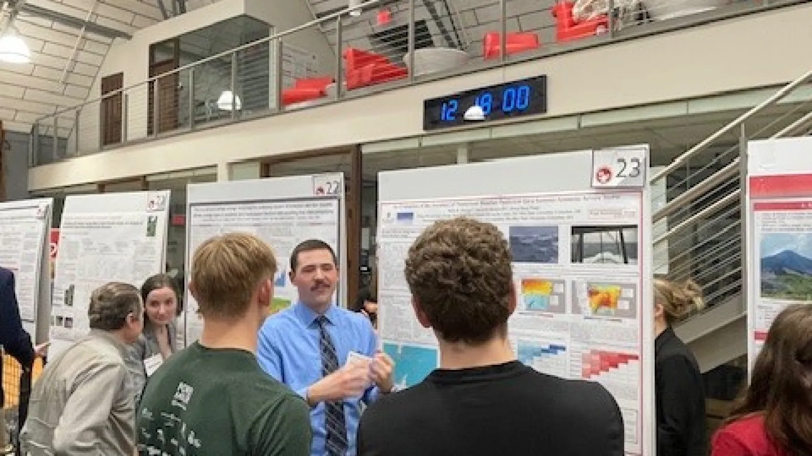 A group standing around a person presenting his poster.