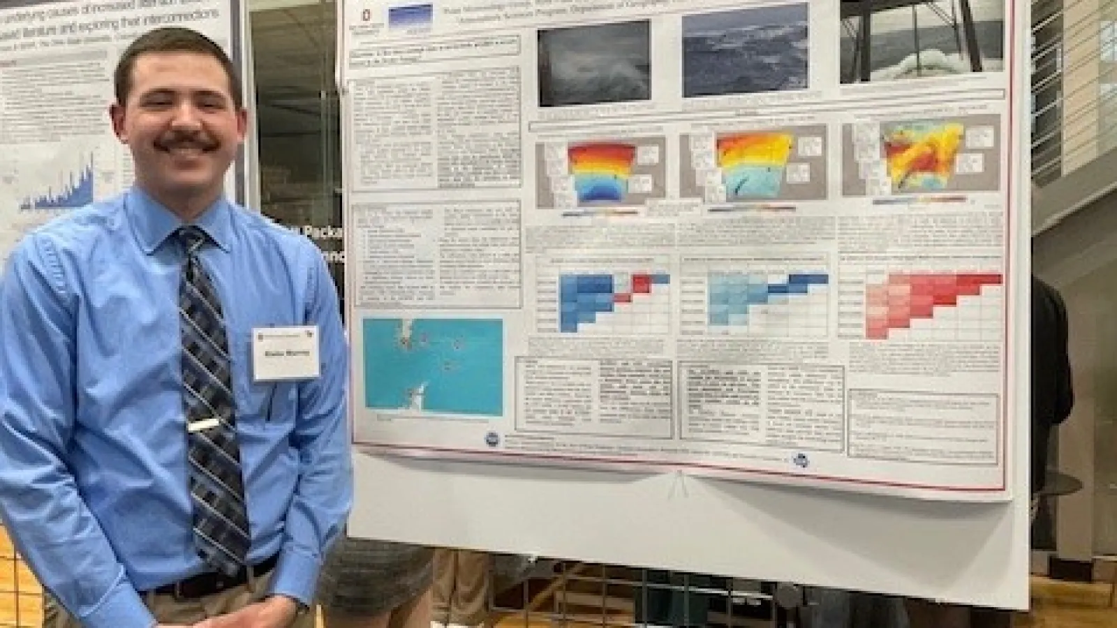 Blake Murray standing in front of his poster.