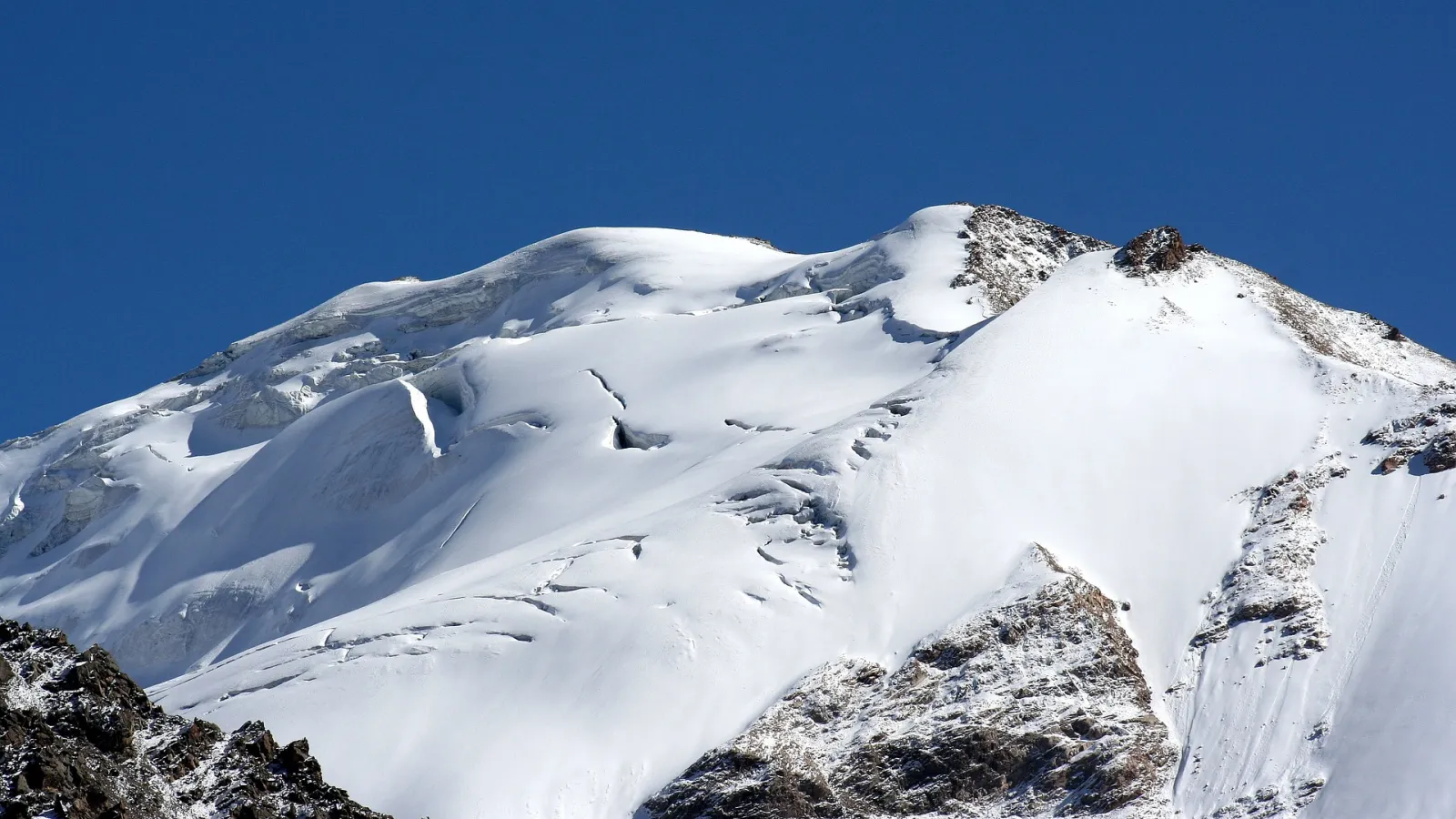 Rocky mountains covered with snow under blue skies.