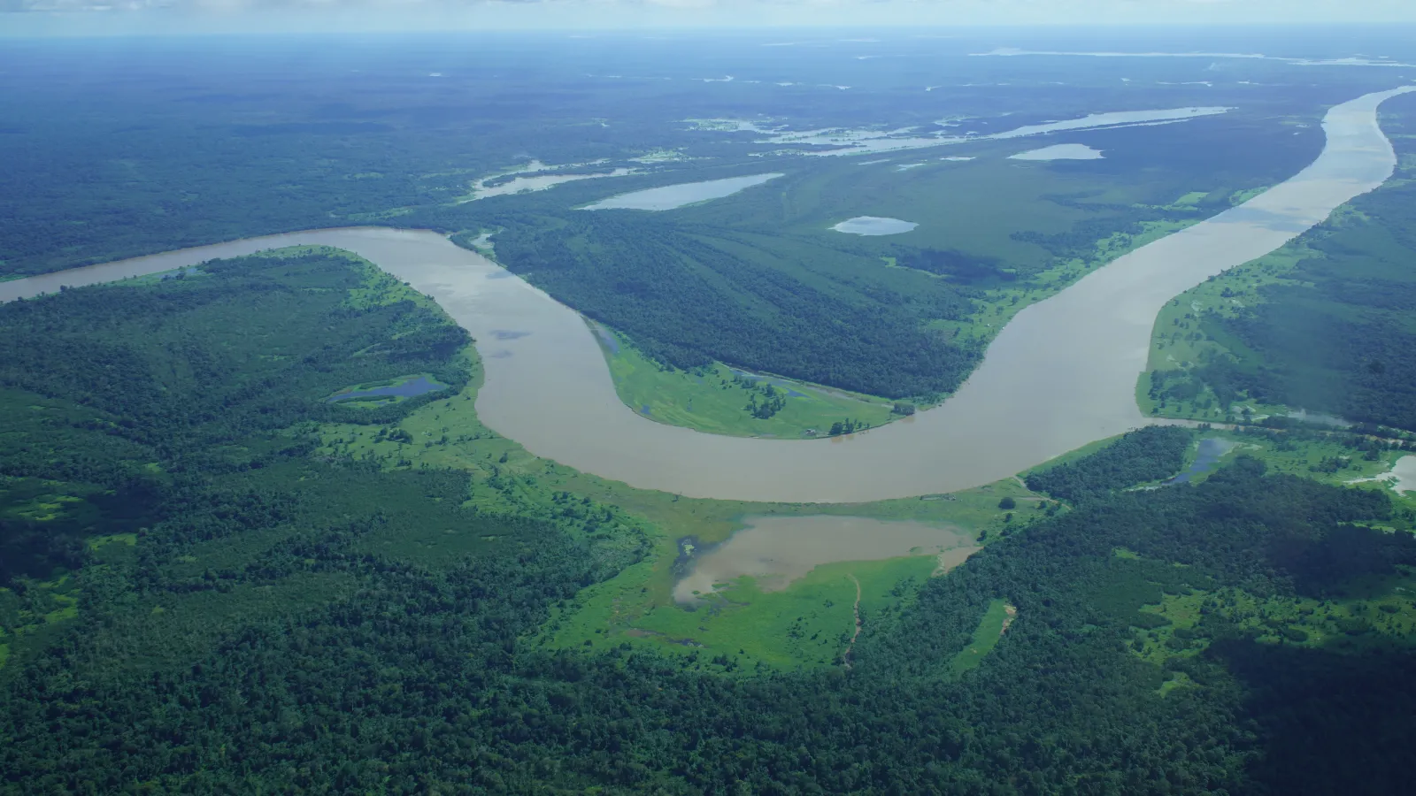 Aerial  of a large river winding in green valley