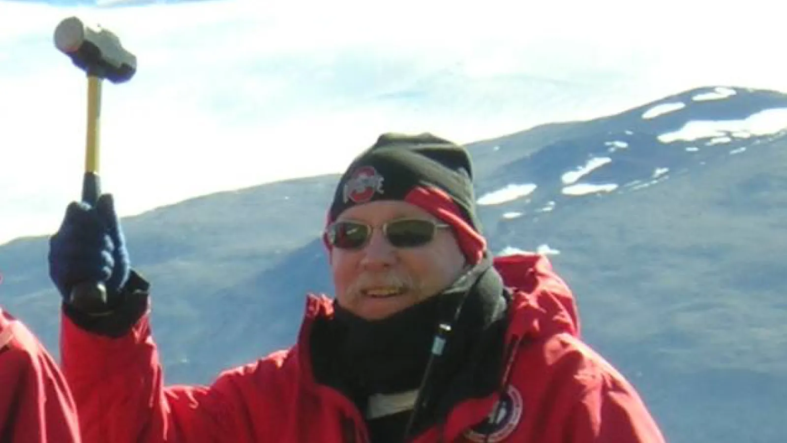 Berry Lyons in Antarctica holding up a mallet