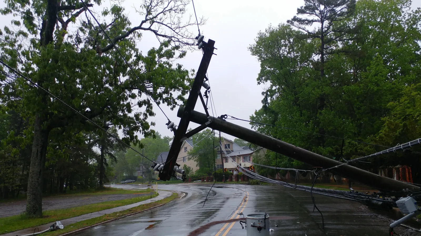 Storm damaged electric transformer on a pole and a tree