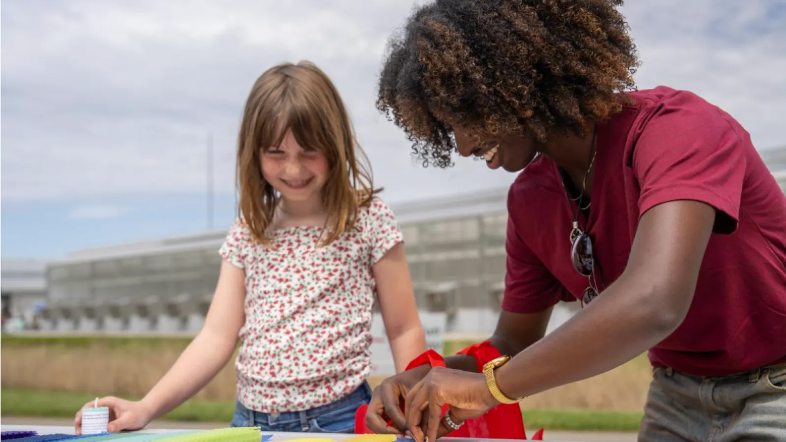 A child and adult smiling as they engage with colored blocks