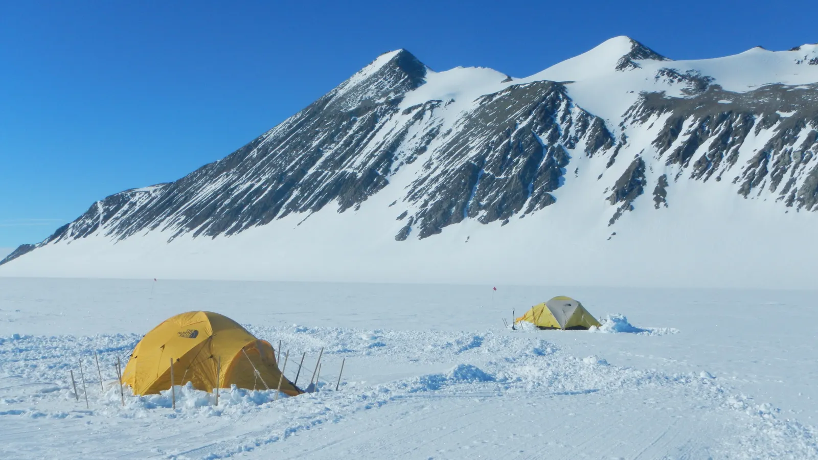 Two tents with mountains in the background