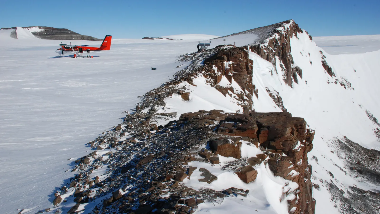 Landscape with rock outcrop, glacier, and airplane