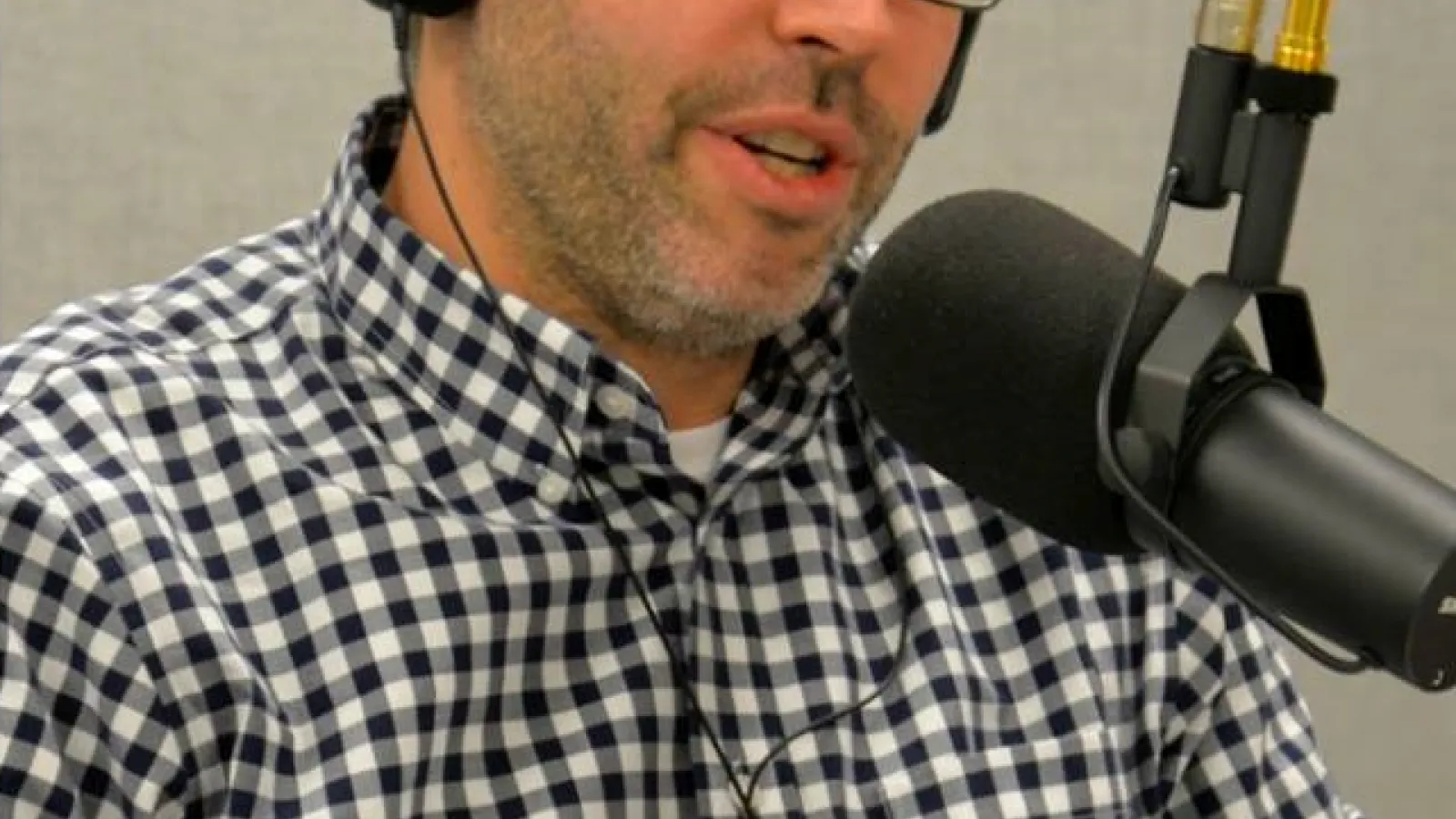 Jason wearing headphones talking into a microphone