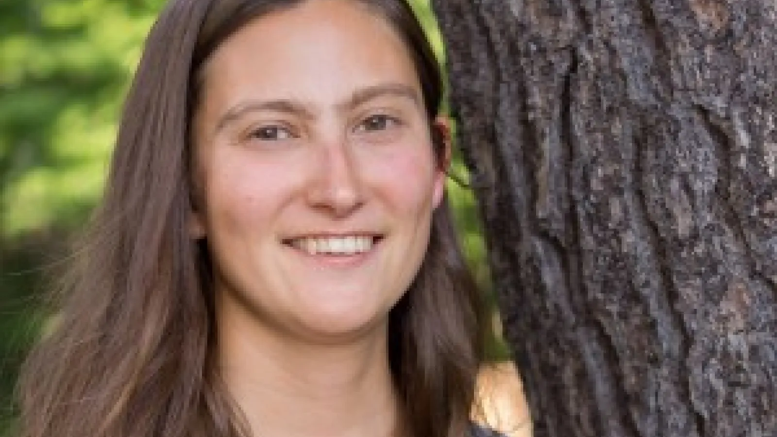 Woman standing next to a tree
