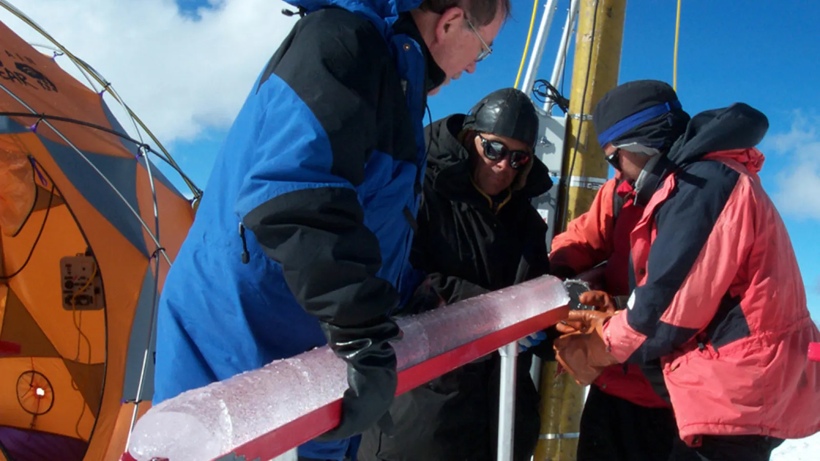 Dr. Lonnie Thompson and two other scientists hold an ice core at the summit of Quelccaya in 2003.