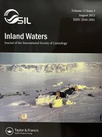 Inland Waters Journal of the International Society of Limnology Cover with SIL and Taylor & Francis logo. and a camp with buildings in a snow covered field, surrounded by mountains under a gray sky.