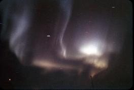 This is an image of the dark, night sky with a white aurora in the center of the image.