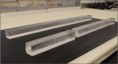 2 short equal length and one long rectangular prism blocks of ice in a black surface.
