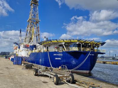 Ship docked during the day under blue skies with white clouds.