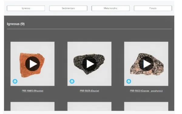 Screen showing the title of virtual Rock Box with 4 white buttons spaced out underneath it with light grey background . White boxes have writing Igneous, Sedimentary, Metamorphic and fossil. Underneath is a dark grey background with Igneous(9) written in white text as if selected then under that   with three rocks each in it's own square white box and a play button on each, showing it is an interactive page.