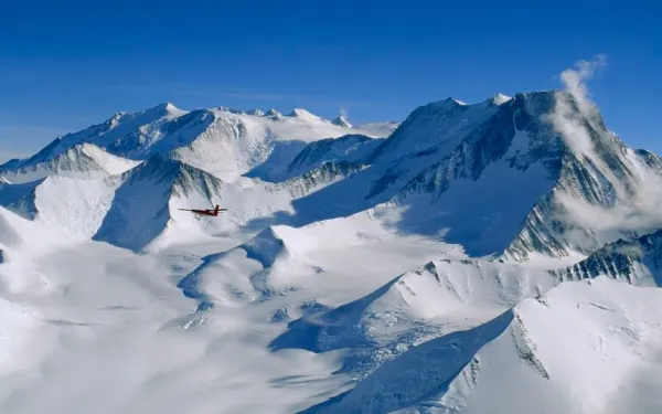 A snow covered mountain range under clear blue skies.