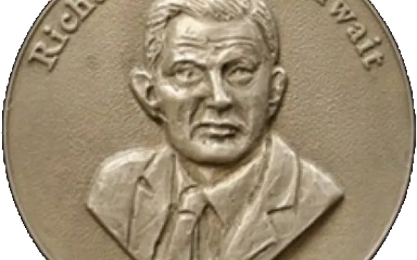 Goldthwait Polar Medal. It is a gold medalion engraved with the head and shoulders of a man with short hair in a suit. On the top and bottom lips of the medalion, the words "Richard P. Goldthwait Award" has been engraved.