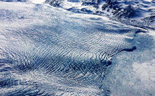 Close-up of a glacier showing ripple like lines in the ice